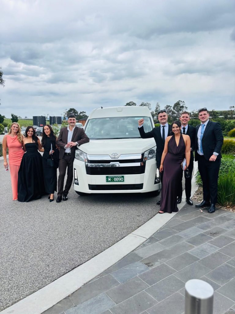 Bride, groom, and wedding guests boarding a white maxi cab